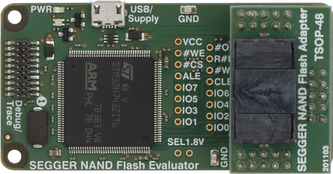 This image shows a SEGGER NAND Flash Evaluator circuit board featuring an ARM microcontroller and various pins for connections. It includes labels for power, ground, and I/O function. The design is primarily green with some black components and clear markings indicating the board's use and specifications.