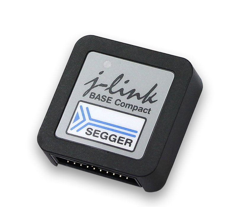 A compact debugging tool labeled "j-link BASE Compact" with the SEGGER logo. It has a rectangular shape with a black casing and a gray top surface featuring the brand name and logo. This device is designed for programming and debugging embedded systems.